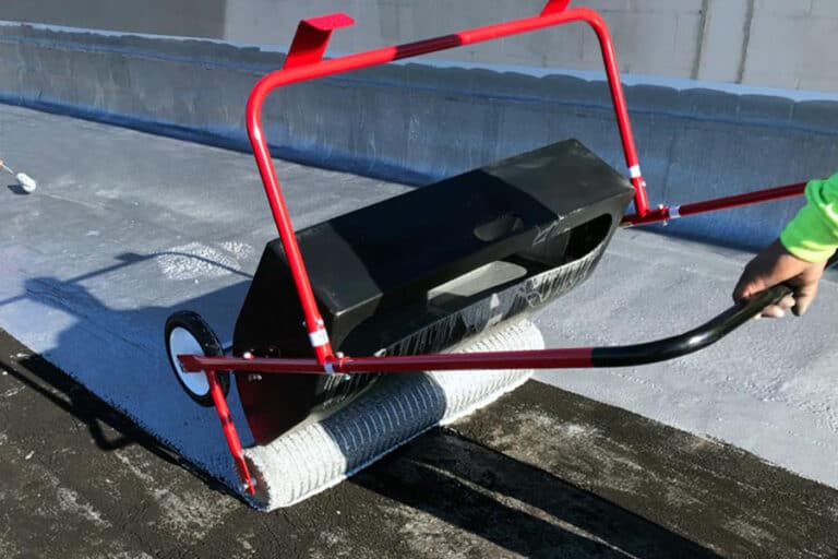 Roofer installing urethane roof coating with a tank spreader, ensuring even application for maximum protection and long-lasting performance.