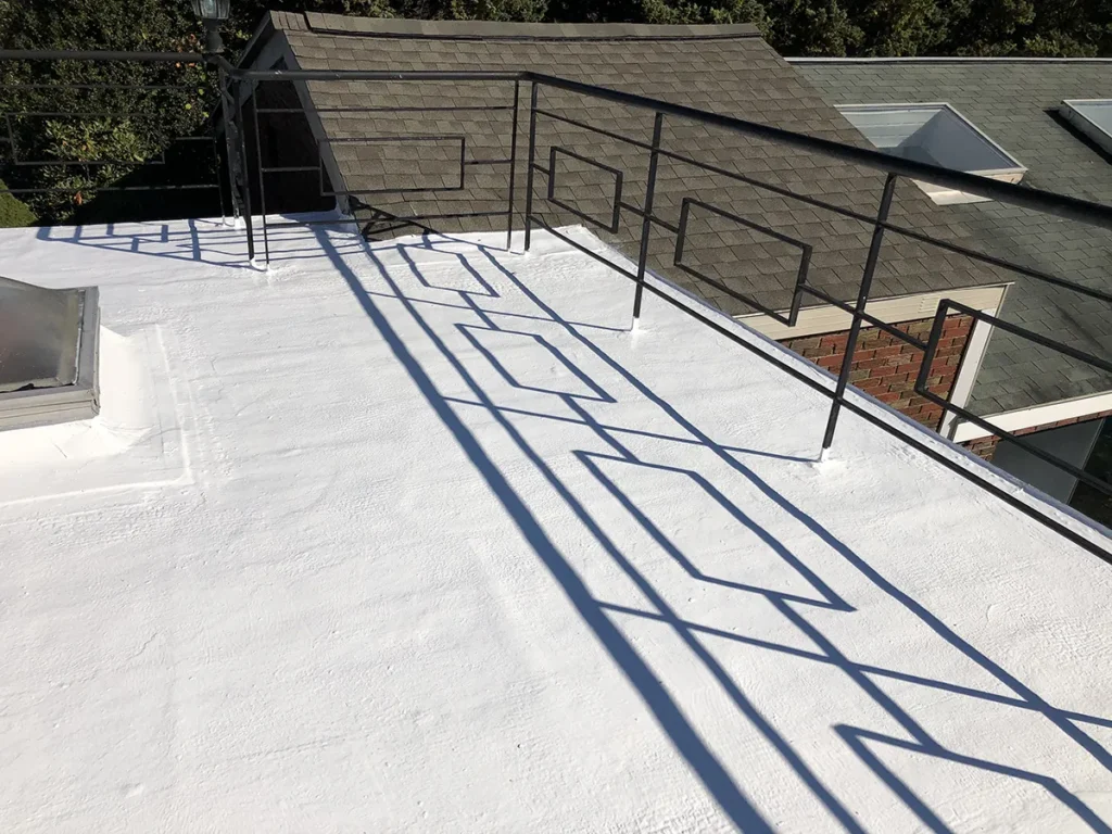 Close up image of high-solids silicone roof coating on small flat roof office building.