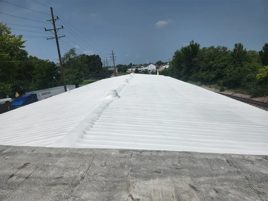 Spray foam roofing system applied to a commercial metal roof, creating a seamless, insulating layer that enhances energy efficiency and waterproofing.