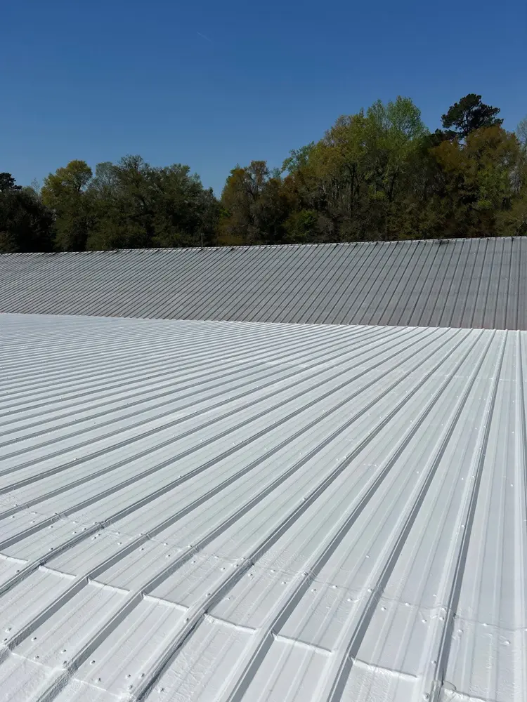 View of partially applied Acrylic 211 top coat of the Met-A-Gard roof restoration system on a commercial metal roof.