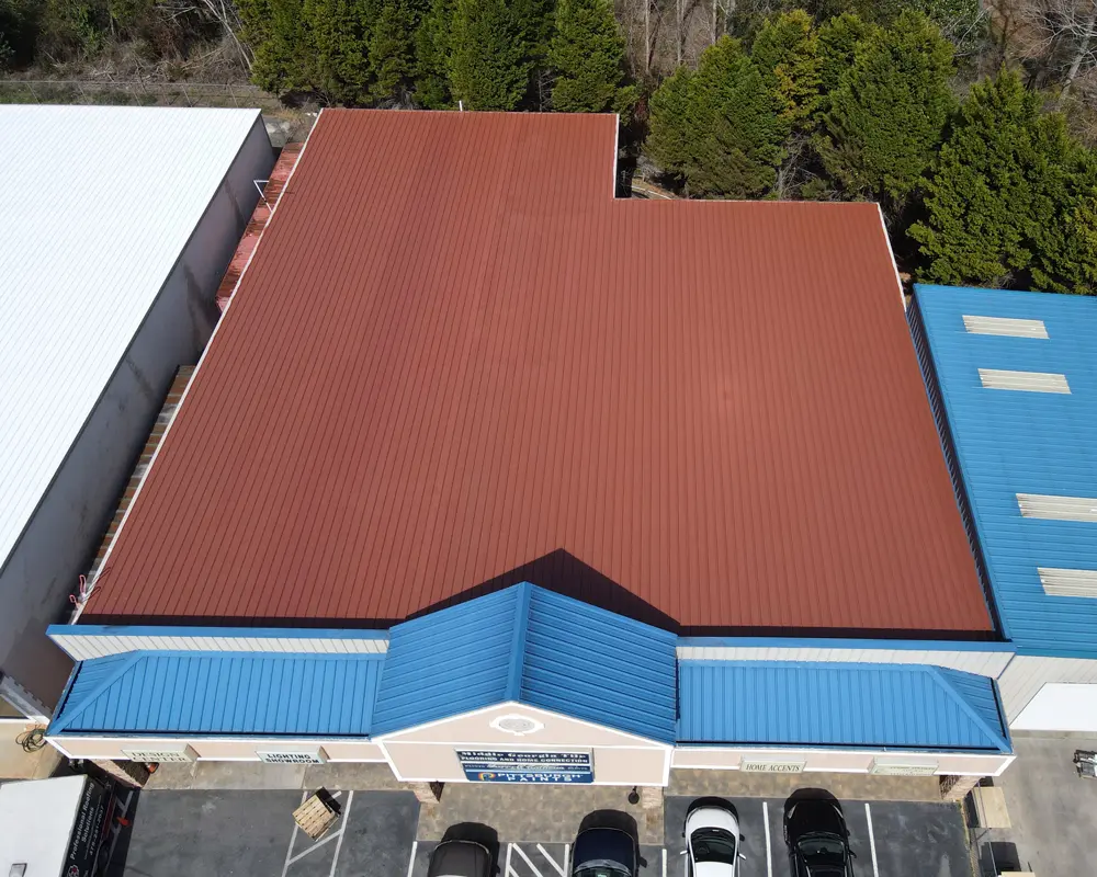 Aerial view of large metal roof with rust primer application (Red Oxide Rust Prime 912), providing long-lasting rust prevention.
