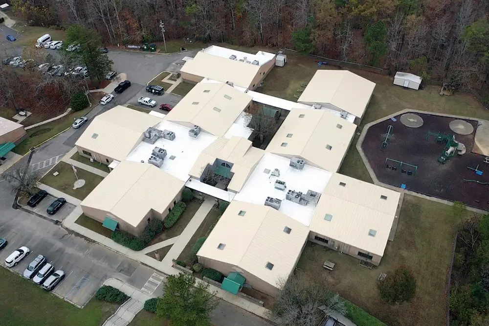 Aerial drone view of school building with custom-tinted Met-A-Gard+ system on a metal roof.