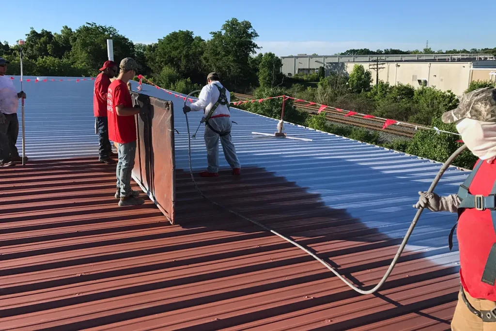 Contractors applying silicone coating of Met-A-Sil system over rust primer