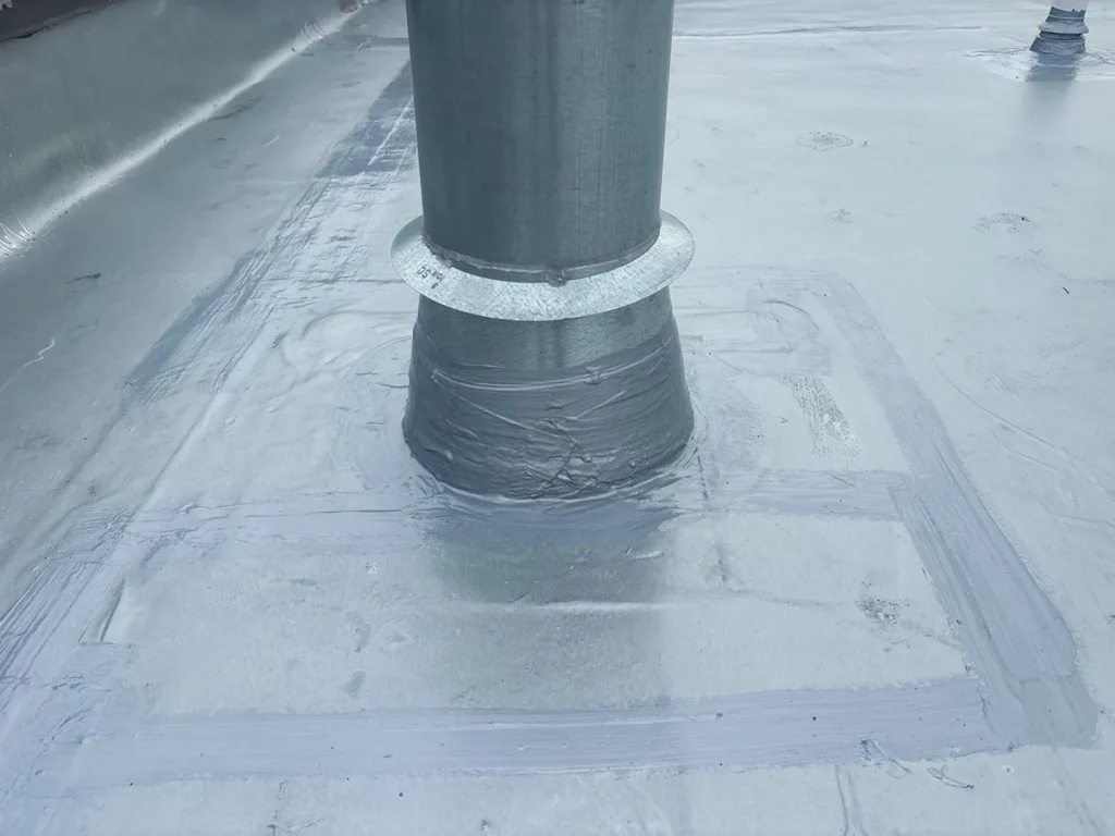 Close up image of penetration on commercial flat roof treated with brush-grade urethane mastic, ensuring durable waterproofing protection.