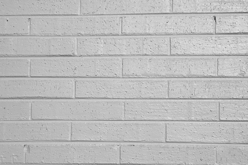 Close-up image of recently coated brick wall showcasing the brilliant finish of the Wall-Coat acrylic wall coating system.
