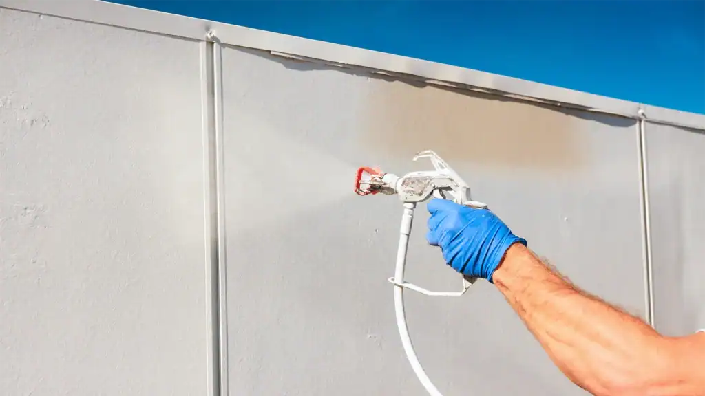 Contractor spraying wall coating