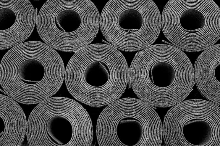 Rolls of modified bitumen stacked and ready for installation, showcasing the material used for durable and weather-resistant roofing systems.