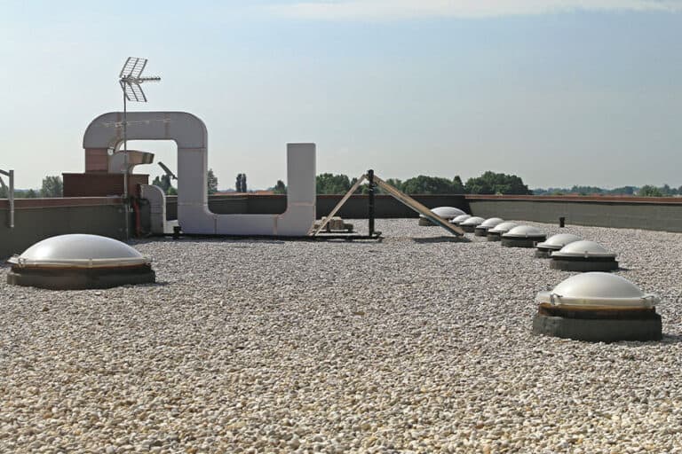 Gravel-covered BUR system on a commercial flat roof, highlighting the protective gravel layer that helps prevent UV damage and enhances the roof's resistance to the elements.