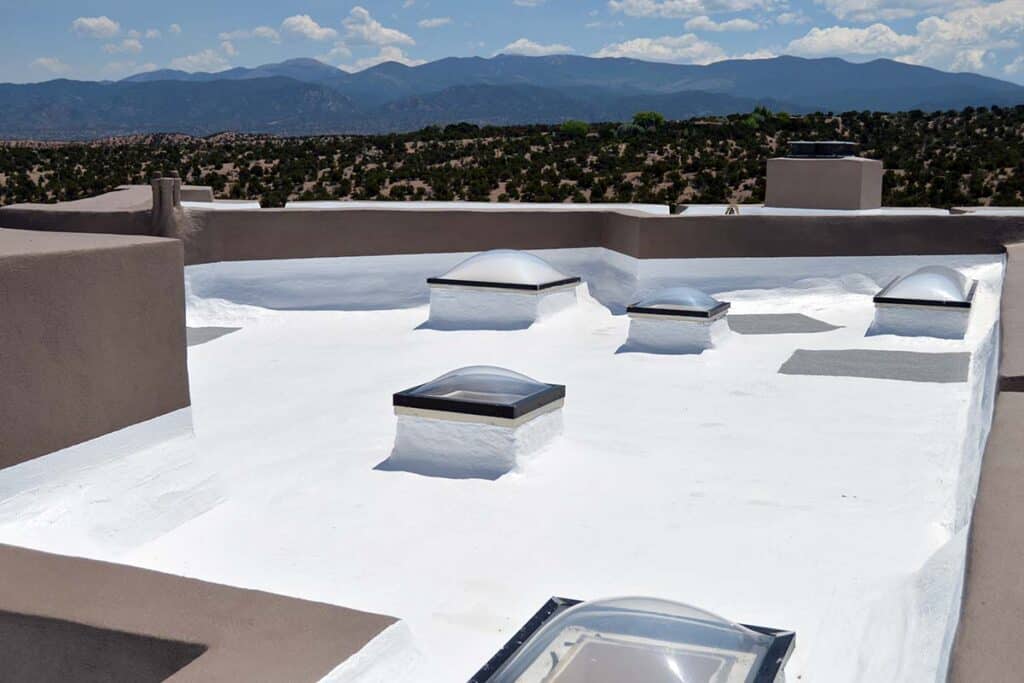 Cool roof coating applied to a flat roof, providing a reflective surface that reduces heat absorption and improves energy efficiency.