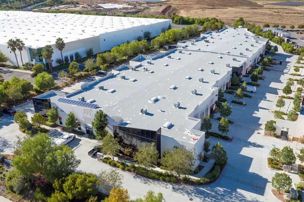 Drone image of a commercial roof, capturing the expansive surface and various roof features, providing a comprehensive view of the roofing system and its condition from above.