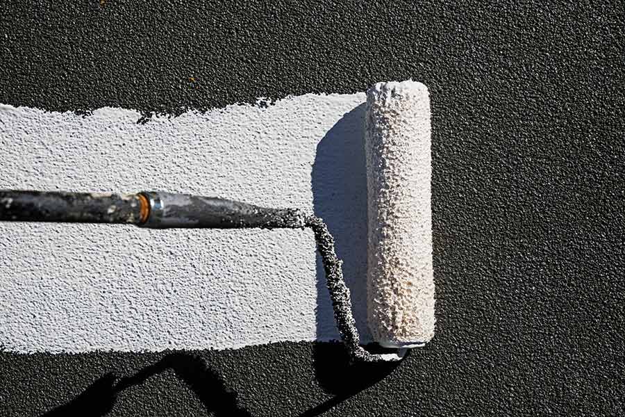 Close-up of a roller applying liquid roofing to a roof, ensuring an even, seamless layer for enhanced waterproofing and long-term protection.