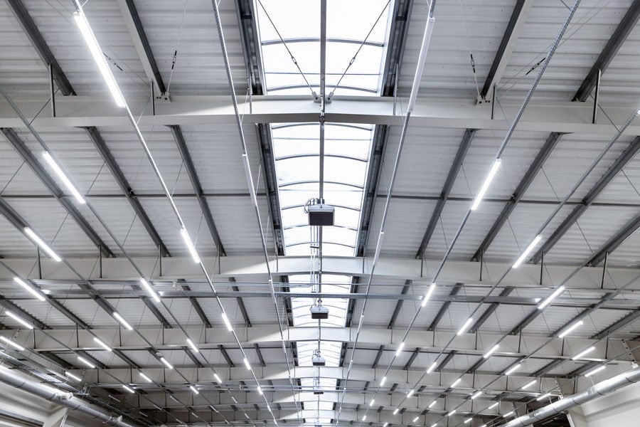 Interior view of a warehouse roof, looking up towards the ceiling, showcasing the structural elements and roofing system from below.