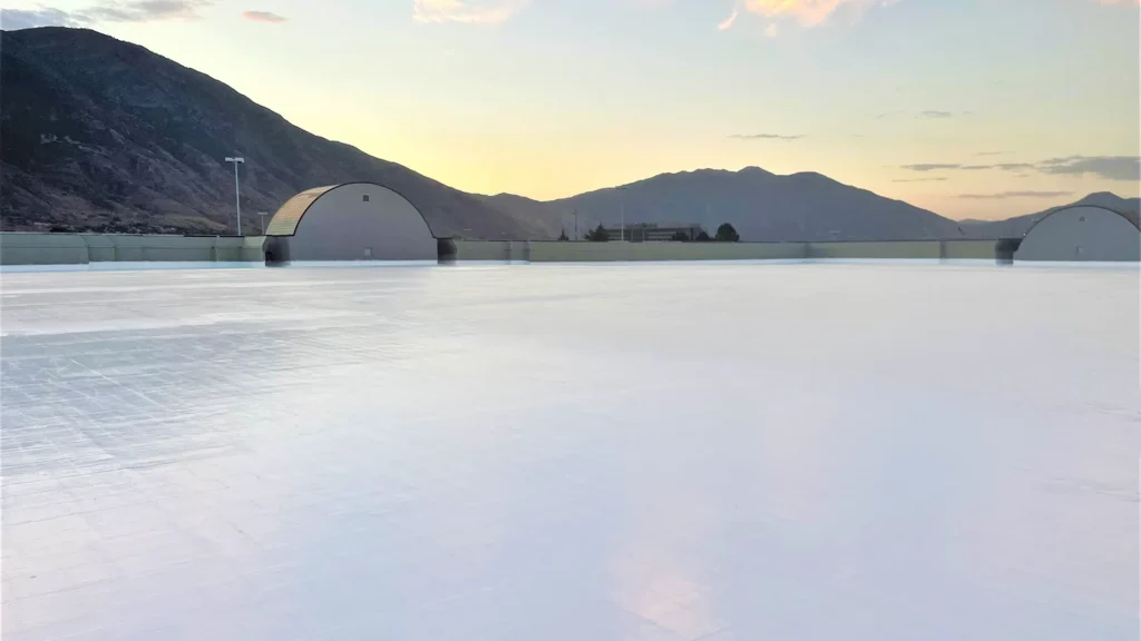 Silicone coatings on large commercial flat roof with mountains in the background