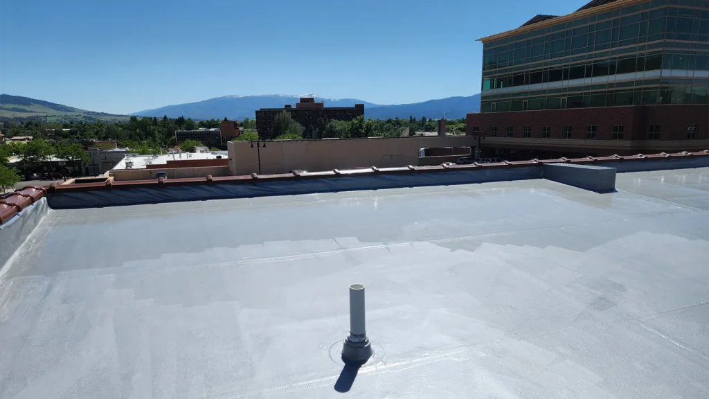 Urethane roof coating on commercial flat roof building in metropolitan area