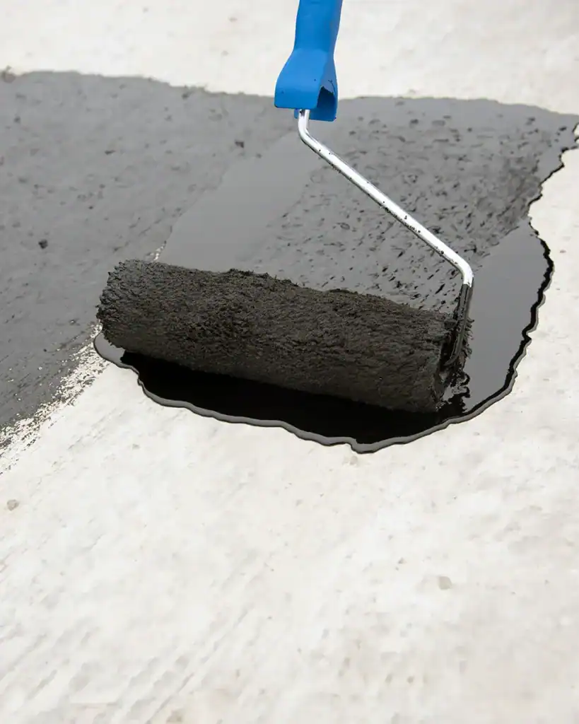 Asphalt emulsion being applied to flat roof