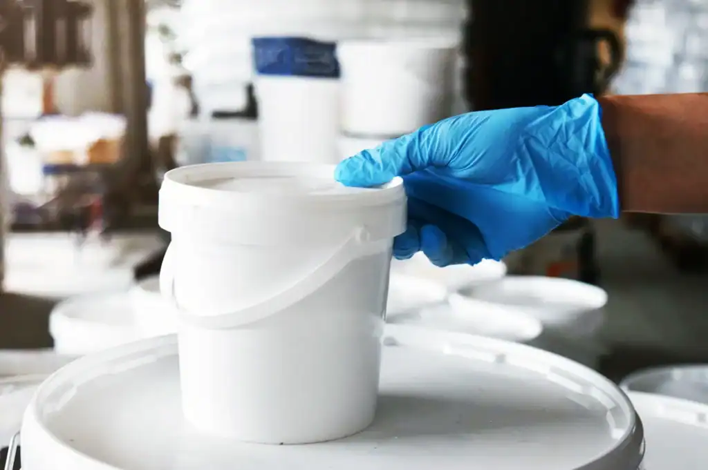 Worker handling liquid coating samples