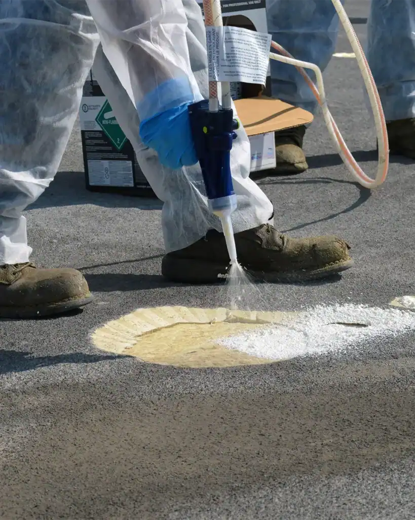 Worker patching hole on roof with spray foam kit