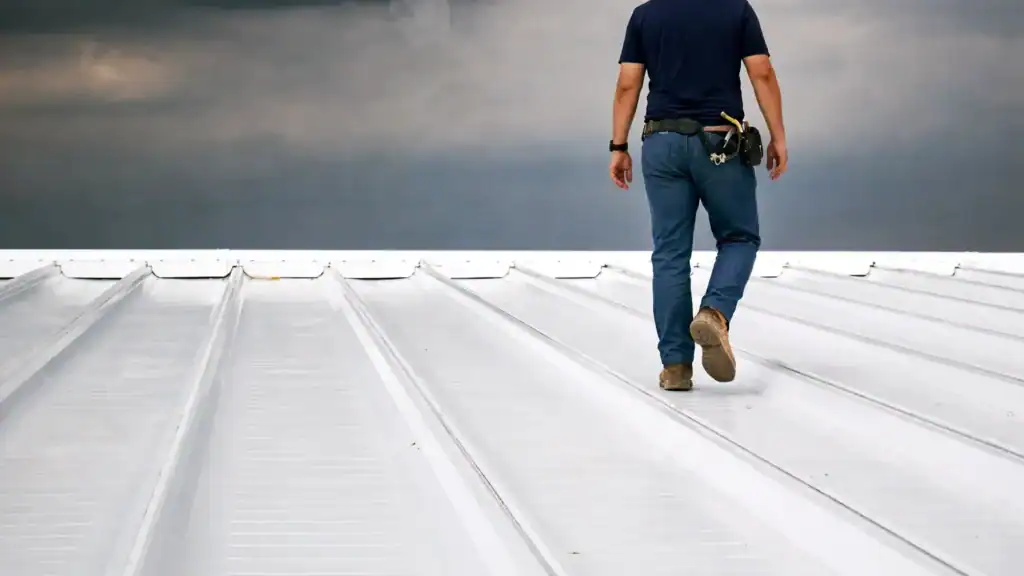 Roofing contractor inspecting commercial metal roof