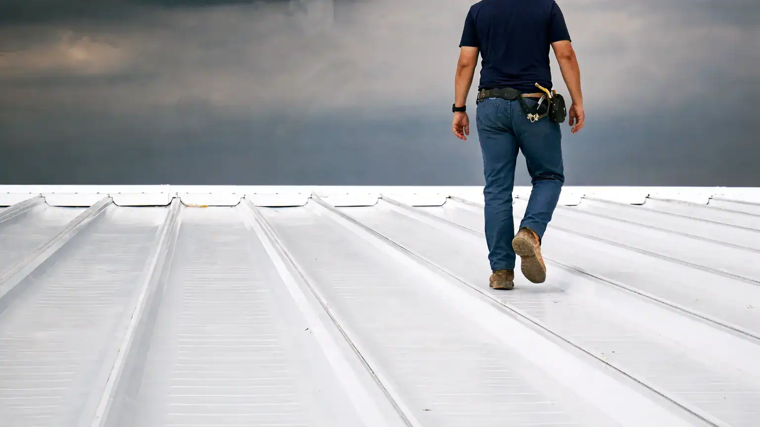 Roofing contractor inspecting commercial metal roof