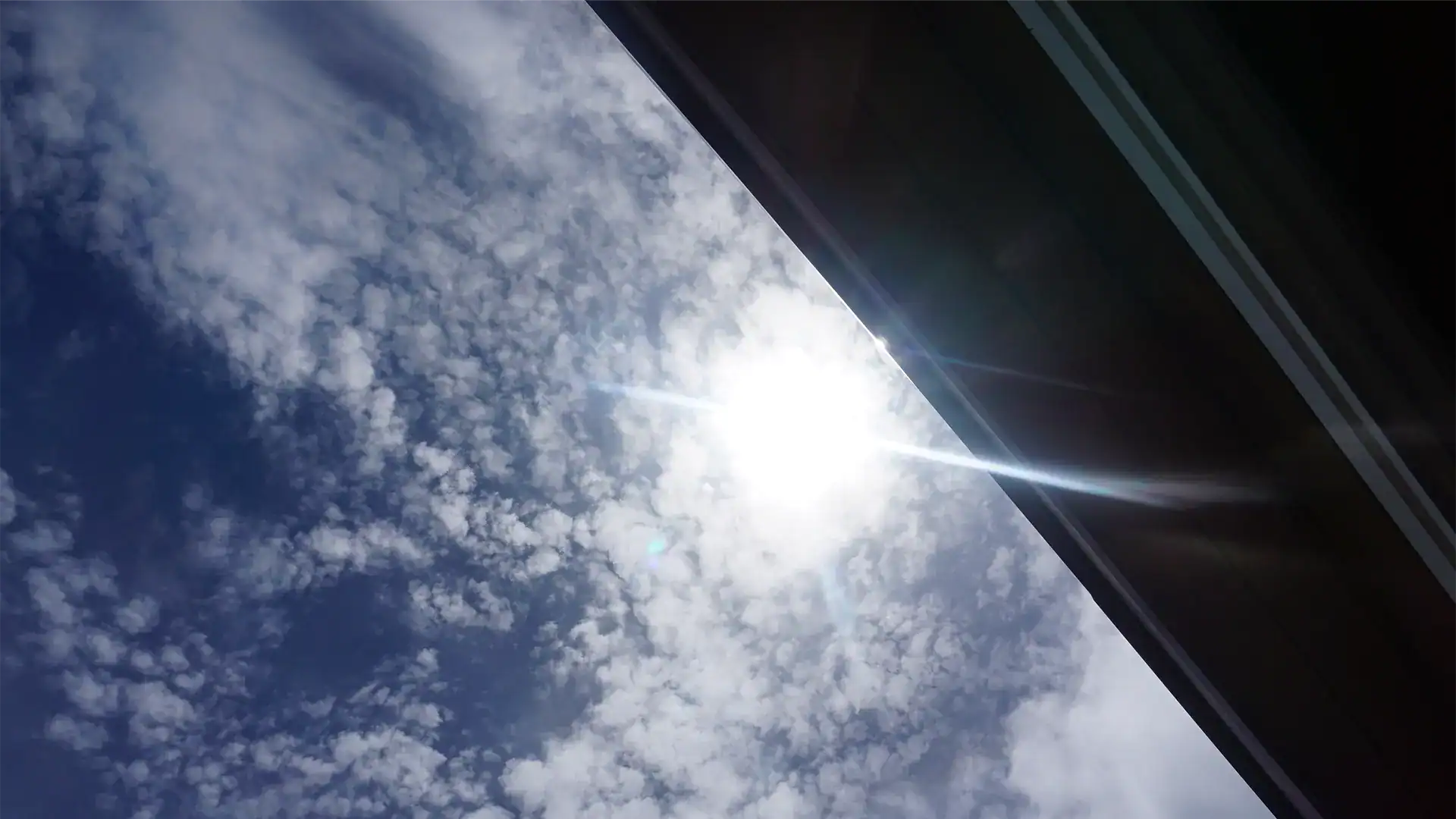 View of sun and sky with commercial roof