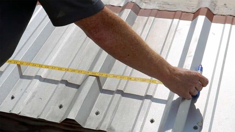 Worker showing how to measure metal roof profile