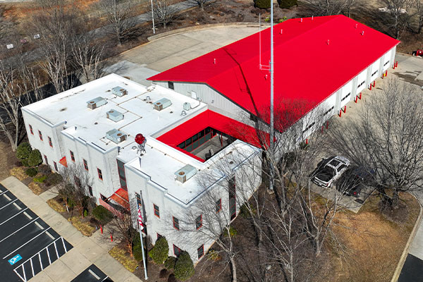 Aerial view of red commercial roof coating applied to metal roof.