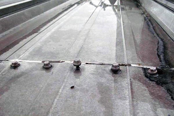 Loose metal roof fasteners between metal roof panels. 